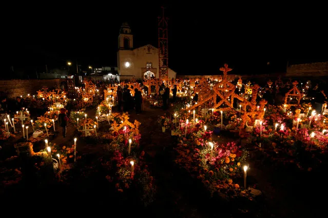 People gather next to the tombs of their loved one on the Day of the Dead at a cemetery in Arocutin, in Michoacan state, Mexico November 1, 2016. (Photo by Alan Ortega/Reuters)