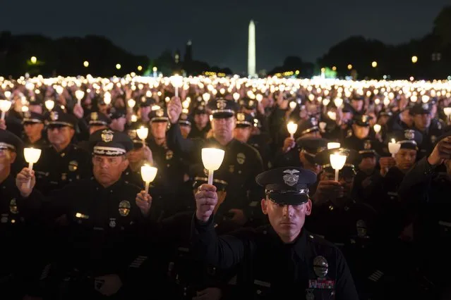 Law enforcement personnel hold candles during the 35th Annual Candlelight Vigil to honor the law enforcement officers who lost their lives in 2022, during the National Police Week at the National Mall in Washington, late Saturday, May 13, 2023. (Photo by Jose Luis Magana/AP Photo)