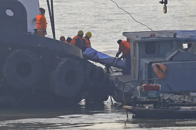 Rescue workers transport a body on a tug boat that sank in the Yangtze River, near Jingjiang, Jiangsu province January 17, 2015. (Photo by Aly Song/Reuters)