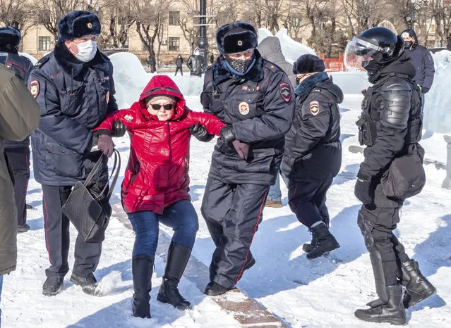 Police officers detain a woman during a protest against the jailing of opposition leader Alexei Navalny in Khabarovsk, 6,100 kilometers (3,800 miles) east of Moscow, Russia, on Sunday, January 31, 2021. Thousands of people took to the streets Sunday across Russia to demand the release of jailed opposition leader Alexei Navalny, keeping up the wave of nationwide protests that have rattled the Kremlin. Hundreds were detained by police. (Photo by Igor Volkov/AP Photo)