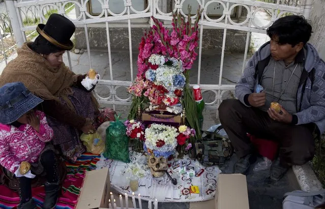 A couple sits with a decorated human skull or “natitas”, during the Natitas Festival celebrations, in La Paz, Bolivia, Tuesday, November 8, 2016. (Photo by Juan Karita/AP Photo)