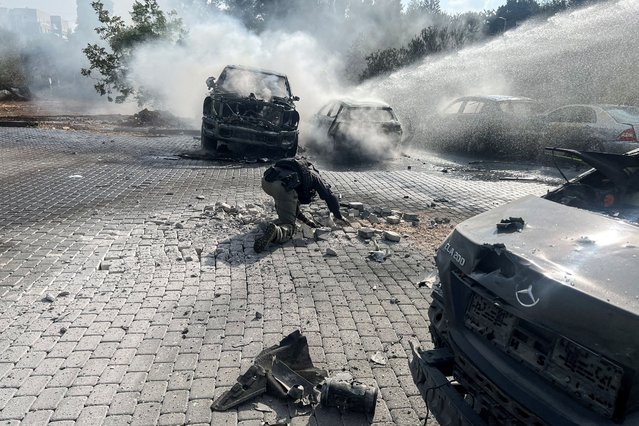 An Israeli police officer investigates at the scene where a rocket fired from Lebanon landed in Israel, amid cross-border hostilities between Hezbollah and Israel, near Israel's border with Lebanon in northern Israel, on October 7, 2024. (Photo by Avi Ohayon/Reuters)