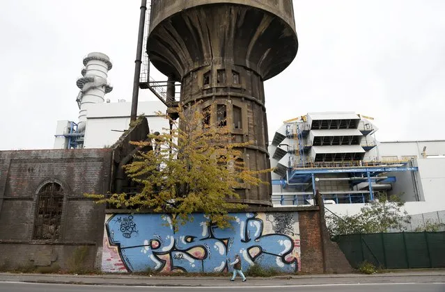 A pedestrian walks in the industrial zone of Charleroi near the site of steelmaking plant Carsid, Belgium, October 21, 2015. (Photo by Francois Lenoir/Reuters)