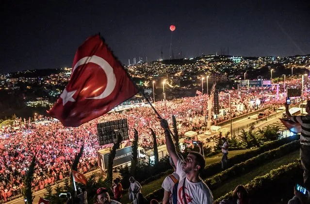 People gather at 15 July Martyrs bridge to attend July 15 coup's second anniversary in Istanbul, on July 15, 2018. (Photo by Bulent Kilic/AFP Photo)