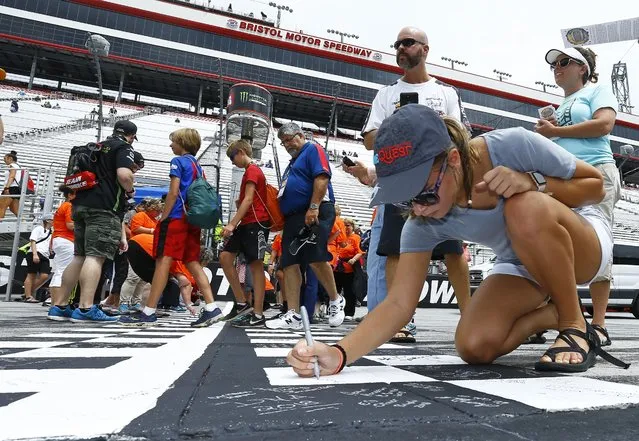 Brook Quarles from Jasper, Georgia signs the starting line before a NASCAR Cup Series auto race, Saturday, August 18, 2018, in Bristol, Tenn. (Photo by Wade Payne/AP Photo)