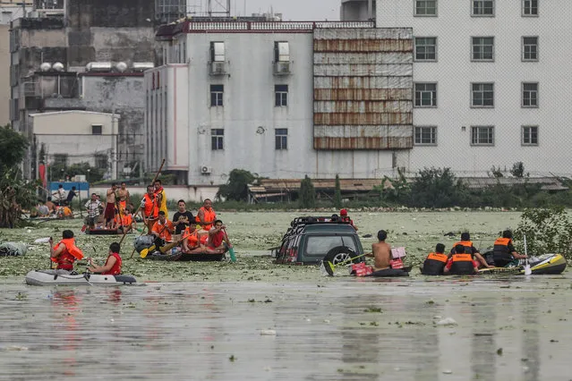 Rescue workers evacuate stranded residents by boat on a flooded street, following heavy rainfall at a village in Shantou, Guangdong province, China September 1, 2018. (Photo by Reuters/China Stringer Network)