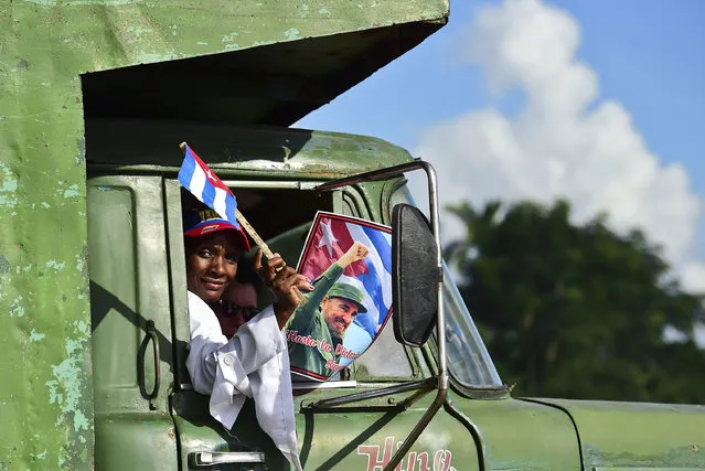People on trucks head towards the convoy carrying the ashes of Cuban leader Fidel Castro, in Jatibonico, on December 1, 2016 during its four-day journey across the island for the burial in Santiago de Cuba. A military jeep is taking the ashes of Fidel Castro on a four-day journey across Cuba, with islanders lining the roads to bid farewell to the late communist icon. Castro died at 90 on November 25, 2016 and will be buried in the eastern city of Santiago de Cuba on Sunday. (Photo by Ronaldo Schemidt/AFP Photo)