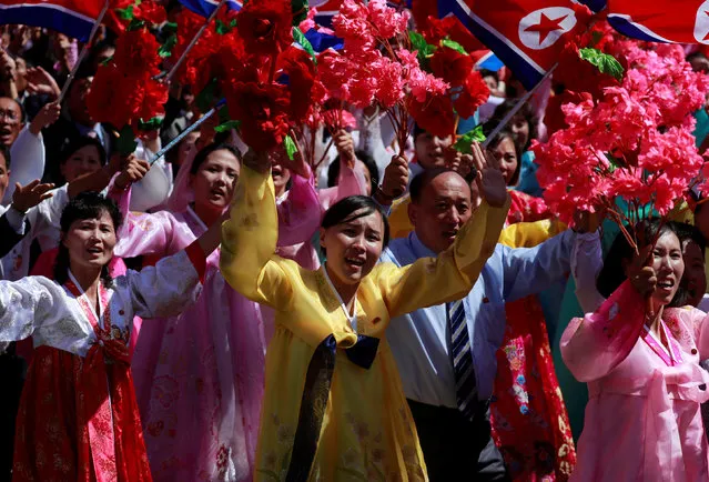 People wave plastic flowers during a military parade marking the 70th anniversary of North Korea's foundation in Pyongyang, North Korea on September 9, 2018. (Photo by Danish Siddiqui/Reuters)