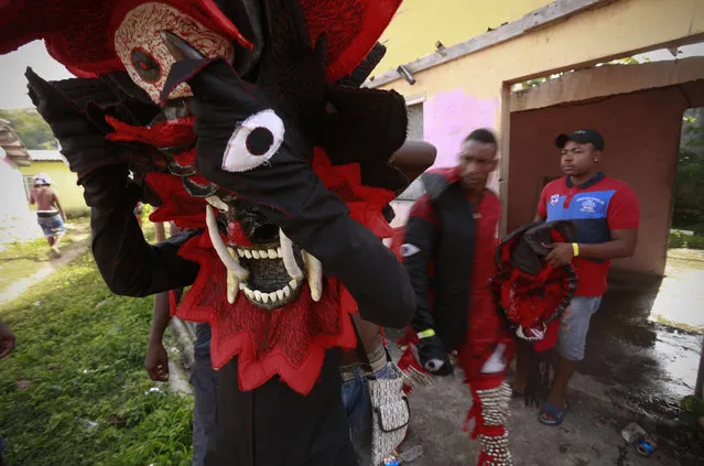 A man puts on his mask as he prepares for the Devils and Congos carnival ritual, in Nombre de Dios, Panama, Wednesday, February 18, 2015. (Photo by Arnulfo Franco/AP Photo)