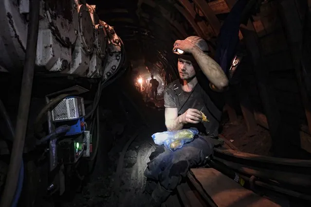 A Bosnian coal miner breaks fast in the underground at a mine in Zenica, Bosnia, Thursday, April 29, 2021. Inside mine shafts, one can't see sunset, but miners consult their watches and smartphones for the right time to sit down, unwrap their food and break their daily fast together. (Photo by Kemal Softic/AP Photo)