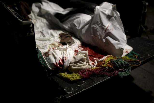 A blood stained bed sheet used by forensic technicians to wrap the body of Alexander Edenilson Escamilla, an alleged member of the MS-13 street gang, is seen on the back of a pick-up truck in Nejapa, on the outskirts of San Salvador, June 25, 2015. (Photo by Jose Cabezas/Reuters)