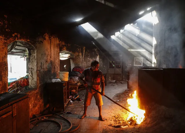 A man lights fire to heat water for soaking clothes at a laundry in Mumbai, India, January 18, 2016. (Photo by Danish Siddiqui/Reuters)