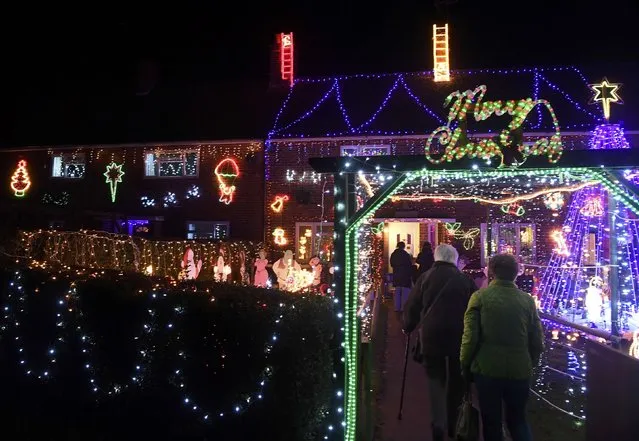 Visitors and locals view Christmas displays on dozens of properties that have been decorated in thousands of lights in a tradition that has grown over recent years in the small village of Westfield in Sussex, south east England, December 15, 2016. (Photo by Toby Melville/Reuters)