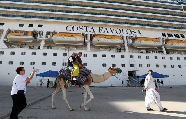 Tourists ride a camel after disembarking a Costa Cruises ship arriving from Italy, at La Goulette port in Tunis, Tunisia, 26 September 2023. The Office of Merchant Shipping and Ports (OMMP) announced the first crossing of the Costa Cruises company, after an absence of eight years due to fears linked to the security situation in Tunisia. (Photo by Mohamed Messara/EPA)