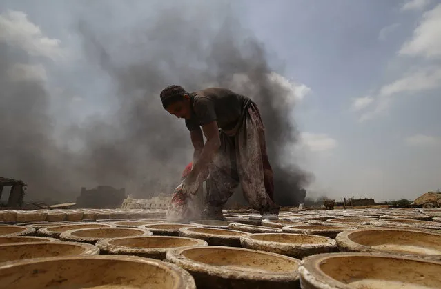 A laborer works at a clay pottery workshop on the outskirts of Karachi, Pakistan, 02 June 2021. The traditional clay pots is regaining its popularity in Pakistan due to its all-natural benefits and affordable prices. Hand-made clay pottery is widely used as household goods in the country. The increasing rates of the US dollar raised the price of Clay pots in the market, while wages of the workers stayed the same. Laborers in pottery industry mostly earns around 200 Rupees (around 1.5 US dollars) a day. (Photo by Shahzaib Akber/EPA/EFE)