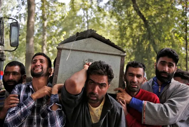 People react as they carry the body of the daughter of an Indian policeman, who according to local media, was killed along with her father and mother by suspected militants, during her funeral in Hariparigam village in south Kashmir's Pulwama district June 28, 2021. (Photo by Danish Ismail/Reuters)