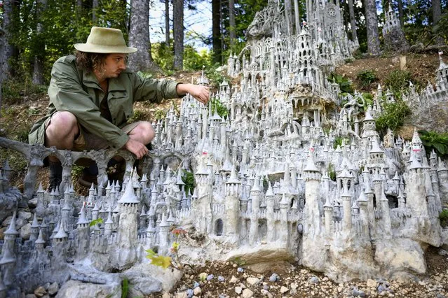 Switzerland's land art artist Francois Monthoux works on his “Citadel of Creation”, made out of clay reinforced with cement, on the forest edge in Biere, Switzerland on September 20 2023. The sculpture is still under construction. After more than 120 days of work, the sculpture measures around 4 metres high and 3 metres wide. (Photo by Laurent Gillieron/EPA)