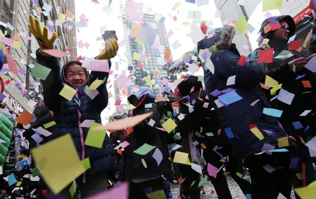 A girl catches confetti as it falls from the Hard Rock Cafe marquee as part of the annual New Year's Eve Confetti Test in Times Square in New York City on December 29, 2016. An estimated one million people will be in Times Square on New Years Eve over a billion will be watching throughout the world. (Photo by UPI/Barcroft Images)
