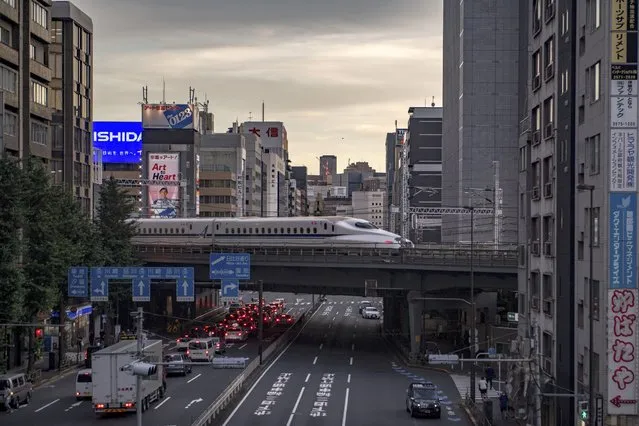 A shinkansen, or high-speed bullet train, travels through Shimbashi area of Tokyo on July 20, 2021 ahead of the Tokyo 2020 Olympics games. (Photo by Philip Fong/AFP Photo)