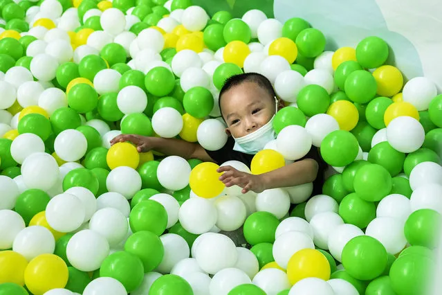 A young boy wearing a mask plays in a playground ball pit in a shopping mall on July 31, 2021 in Wuhan, Hubei Province, China. A new round spreading of Covid-19 has started from Nanjing, prompting provinces and cities to take action to fend off the epidemic. With no recorded cases of COVID-19 community transmissions since May 2020, life for residents in Wuhan is gradually returning to normal. (Photo by Getty Images/China Stringer Network)