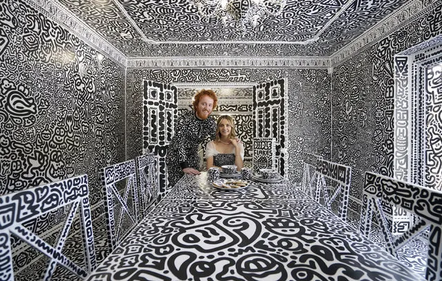 British artist Sam Cox, aka Mr Doodle and his wife Alena, pose for a photo in the Doodle House, a twelve-room mansion, in Tenterden, which has been covered, inside and out in the artist's trademark monochrome, cartoonish hand-drawn doodles, in Kent, England, Monday, October 3, 2022. (Photo by Gareth Fuller/PA Wire/PA via AP Photo)