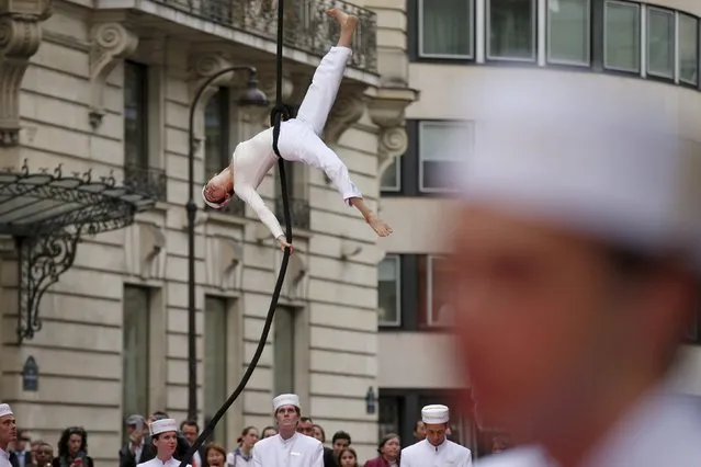 An acrobat performs as guests arrive for the official inauguration party of Peninsula Paris luxury hotel in Paris April 16, 2015. (Photo by Benoit Tessier/Reuters)