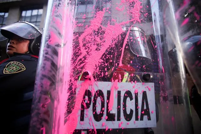 Pink paint is seen on a police shield as police officers stand guard during a protest to mark the International Day for the Elimination of Violence Against Women, in Mexico City, Mexico on November 25, 2022. (Photo by Quetzalli Nicte-Ha/Reuters)