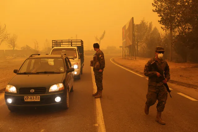 Soldiers stand guard on a road as the worst wildfires in Chile's modern history ravaged wide swaths of the country's central-south regions, in Santa Olga, Chile January 26, 2017. (Photo by Pablo Sanhueza/Reuters)