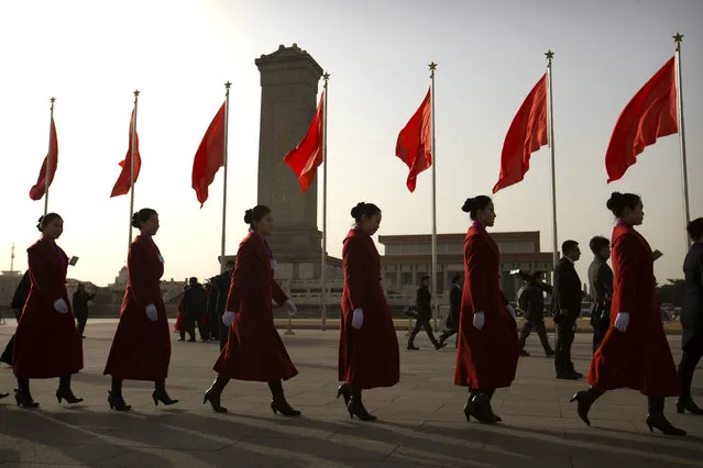 Hostesses, who facilitated the arrival of delegates by bus, walk across Tiananmen Square near the Great Hall of the People during the opening session of China's annual National People's Congress (NPC) in Beijing, Saturday, March 5, 2016. (Photo by Mark Schiefelbein/AP Photo)