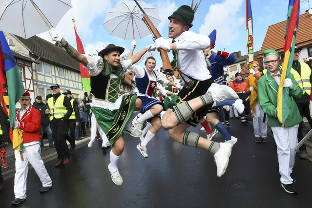 People jumps on the street during a carnival parade in Herbstein, Germany, Monday, March 4, 2019. (Photo by Uwe Zucchi/dpa via AP Photo)