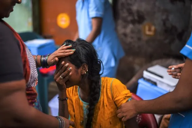 A woman reacts while receiving a dose of the COVID-19 vaccine at a slum during the fourth mega vaccination drive against the COVID-19 coronavirus disease, in Chennai, India, 03 October 2021. The Tamil Nadu state government organised the fourth mega COVID-19 vaccination drive to vaccinate more people across the state. So far, India has administered over 900 million cumulative COVID-19 vaccines, Union Minister for Health and Family Welfare Mansukh Mandaviya said on 02 October. (Photo by Idrees Mohammed/EPA/EFE)