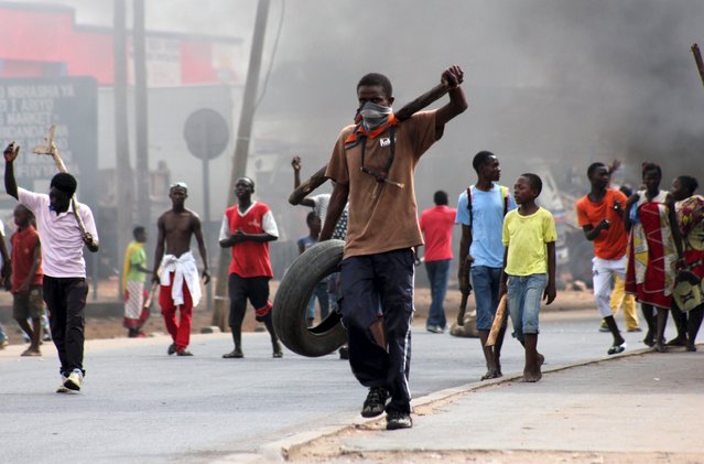 A protester carries a tyre to be used to erect a barricade as they demonstrate against the ruling CNDD-FDD party's decision to allow Burundian President Pierre Nkurunziza to run for a third five-year term in office, in Bujumbura, May 7, 2015. Protesters were back on the streets of Burundi's capital on Thursday and one person was killed after President Pierre Nkurunziza told demonstrators to halt rallies against his third term bid, promising to make it his last if he wins. (Photo by Jean Pierre Aime Harerimana/Reuters)