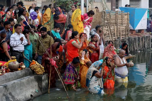 Hindu devotees worship the Sun god during the religious festival of Chhath Puja at a pond in Kolkata, India, November 11, 2021. (Photo by Rupak De Chowdhuri/Reuters)