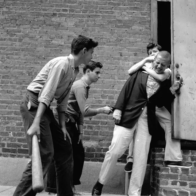 A teenage street gang carry out a mugging in a deserted alley in New York City, circa 1955. (Photo by Carl Purcell/Three Lions/Getty Images)