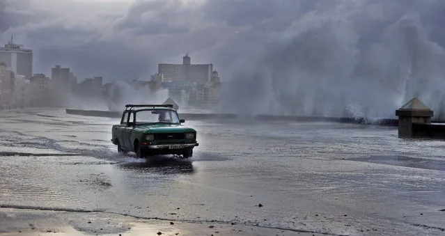 A car passes through an area of the boardwalk hit by strong waves in Havana, Cuba, 05 February 2024. The Cuban Institute of Meteorology (Insmet) recorded strong gusts of wind of up to 104 kilometers per hour and strong waves in the west of the island due to a cold front associated with an “extratropical low”. (Photo by Ernesto Mastrascusa/EPA)