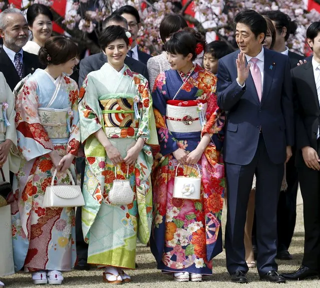 Japan's Prime Minister Shinzo Abe (R) poses with kimono-clad show-business celebrities at a cherry blossom viewing party at Shinjuku Gyoen park in Tokyo, Japan April 9, 2016. (Photo by Toru Hanai/Reuters)