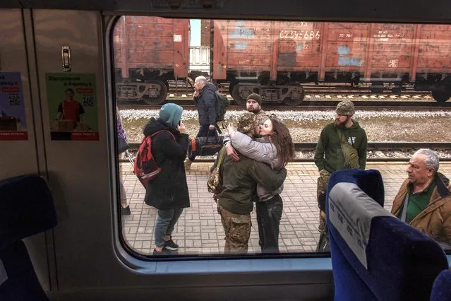 A Ukrainian serviceman kisses his partner who arrived on a train coming from Kyiv, at a railway station in Sloviansk, Donetsk region, on March 26, 2024, amid the Russian invasion of Ukraine. (Photo by Roman Pilipey/AFP Photo)