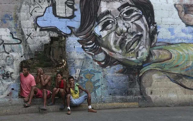 A group of young people rest in a hole in the wall at the Agua Salud neighborhood of Caracas, Venezuela, Wednesday, May 15, 2019. More than 3 million Venezuelans have left their homeland in recent years amid skyrocketing inflation and shortages of food and medicine. U.S. administration officials have warned that 2 million more are expected to flee by the end of the year if the crisis continues in the oil-rich nation. (Photo by Martin Mejia/AP Photo)