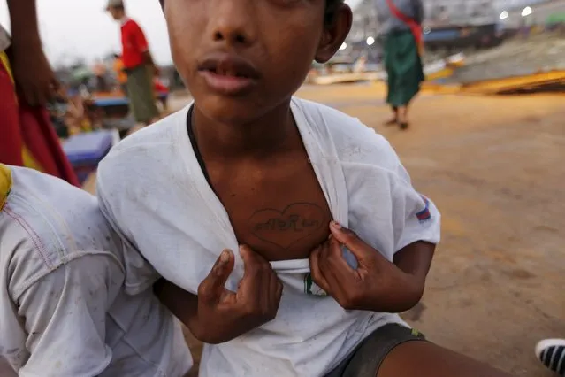 Nay Htet Lin, a 15-year-old worker, shows a heart-shaped tattoo on his chest of his mother's name at San Pya fish market in Yangon, Myanmar February 19, 2016. (Photo by Soe Zeya Tun/Reuters)