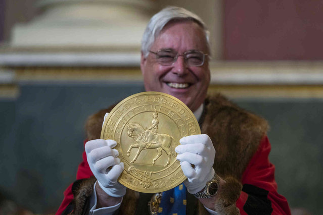 A 15-kilogram (33-pound) gold coin produced to celebrate the late Queen Elizabeth II's Platinum Jubilee, is assessed during the “Trial of the Pyx”,' a ceremony that dates to the 12th Century in which coins are weighed in order to make certain they are up to standard, at the Goldsmiths' Hall in London, Tuesday, February 7, 2023. A jury sat solemnly in a gilded hall in central London on Tuesday, presided over by a bewigged representative of the crown in flowing black robes, but there were no criminals in the dock. (Photo by Kin Cheung/AP Photo)