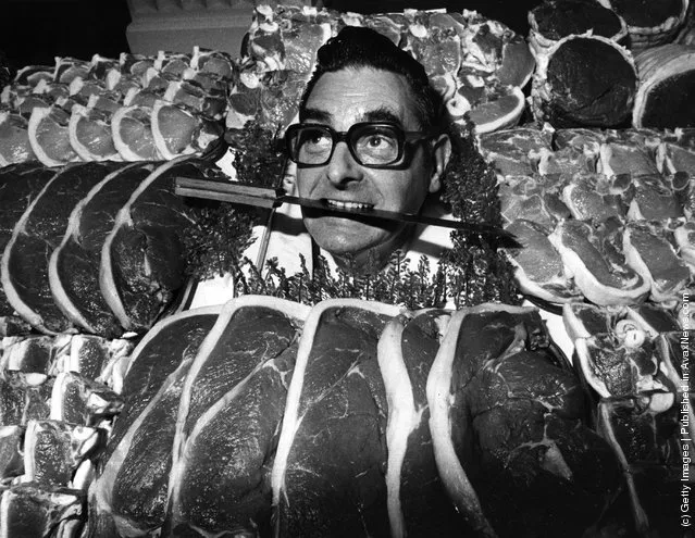 1975: The winner of the Dewhurst's Master Butcher of the Year, James Pegg,  poses with a knife between his teeth and a selection of meat