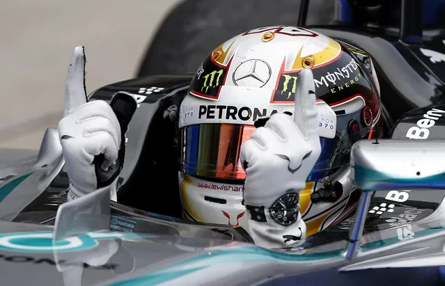 Mercedes driver Lewis Hamilton of Britain gestures in his car after winning the Malaysian Formula One Grand Prix at Sepang International Circuit in Sepang, Malaysia, Sunday, March 30, 2014. (Photo by Vincent Thian/AP Photo)