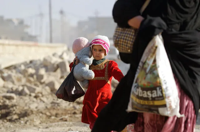 A displaced Iraqi girl carries her doll as she flees her home while Iraqi forces battle with Islamic State militants, in western Mosul, Iraq March 7, 2017. (Photo by Zohra Bensemra/Reuters)