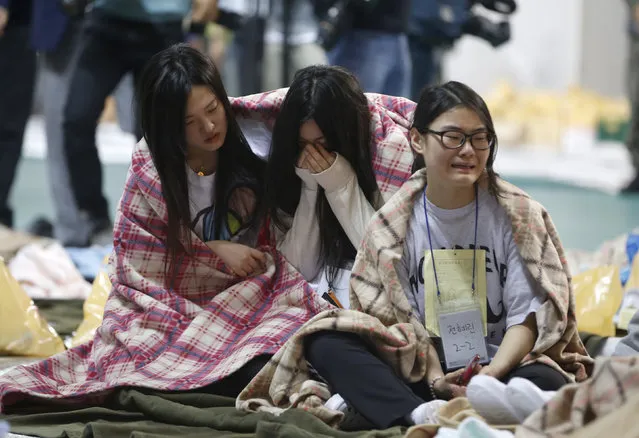 Rescued passengers cry at a gym where rescued passengers gather in Jindo April 16, 2014. More than 300 people were missing after a ferry sank off South Korea, the coastguard said on Wednesday, with a three-fold increase in the number of passengers unaccounted for put down to a miscalculation by officials. The ferry Sewol was carrying 477 people, of whom 164 were confirmed rescued, coastguard officials said. (Photo by Kim Hong-Ji/Reuters)