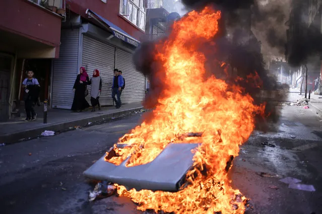 Leftist demonstrators set on fire a barricade as they clash with riot police using tear gas to disperse them during May Day celebrations in Istanbul, Sunday, May 1, 2016. (Photo by Cagdas Erdogan/AP Photo)
