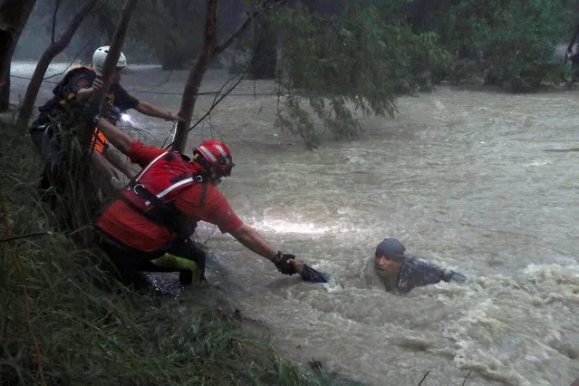 Rescue workers rescue a man from strong currents of La Silla river during Tropical Storm Fernand in the municipality of Guadalupe, in Nuevo Leon state, Mexico, September 4, 2019. (Photo by Reuters/Stringer)