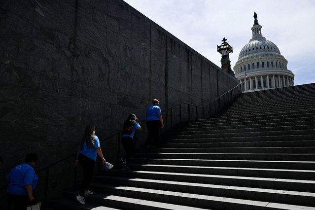 Visitors ascend the last remaining part of shade of a set of stairs on Capitol Hill amid a heat wave in Washington on June 19, 2024. (Photo by Craig Hudson/Reuters)