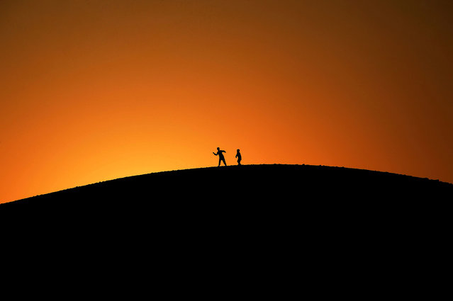In this photograph taken on February 12, 2017, Afghan youth play on a hilltop as the sun sets on the outskirts of Jalalabad. (Photo by Noorullah Shirzada/AFP Photo)