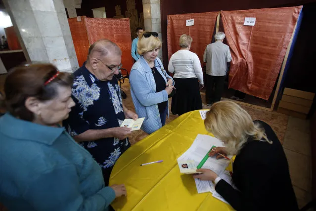 People wait in line at a polling station in the center of Slovyansk, eastern Ukraine, Sunday, May 11, 2014. Residents of two restive regions in eastern Ukraine engulfed by a pro-Russian insurgency are casting ballots in contentious and hastily organized independence referenda. Sunday's ballots seek approval for declaring so-called sovereign people's republics in the Donetsk and Luhansk regions, where rebels have seized government buildings and clashed with police and Ukrainian troops. (Photo by Darko Vojinovic/AP Photo)