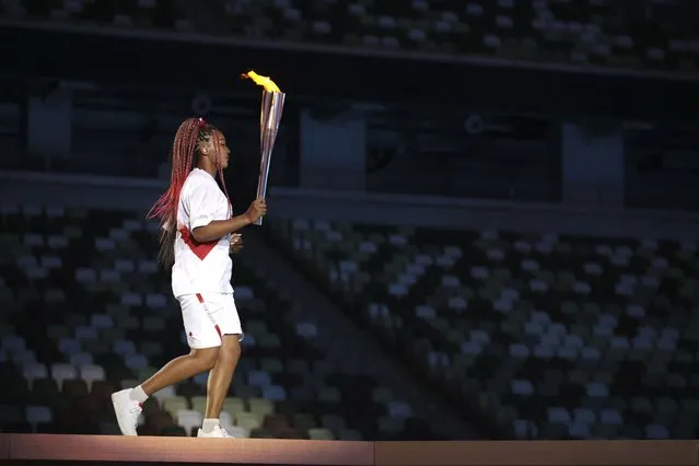 Naomi Osaka carries the Olympic Torch during the opening ceremony in the Olympic Stadium at the 2020 Summer Olympics, Friday, July 23, 2021, in Tokyo, Japan. (Photo by Hannah McKay/Pool Photo via AP Photo)